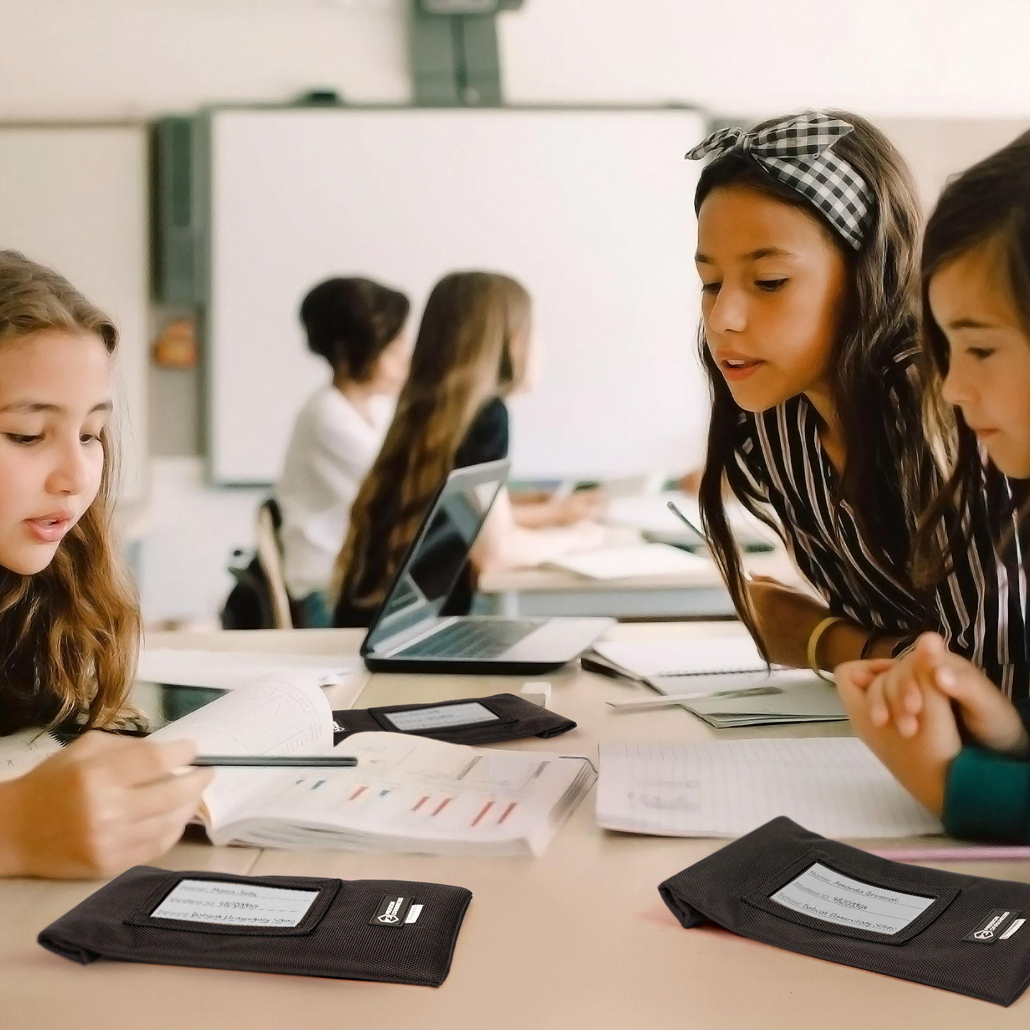 Students collaborating with Generation Faraday bags on desk